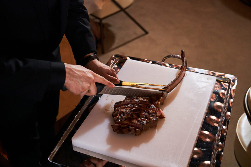 A server slices meat table-side at The Wake restaurant.